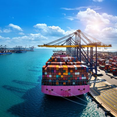 Aerial view of cargo ship and cargo container in harbor.